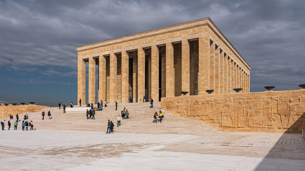 Wide view of Anıtkabir mausoleum and visitors under a dramatic sky in Ankara, Turkey.