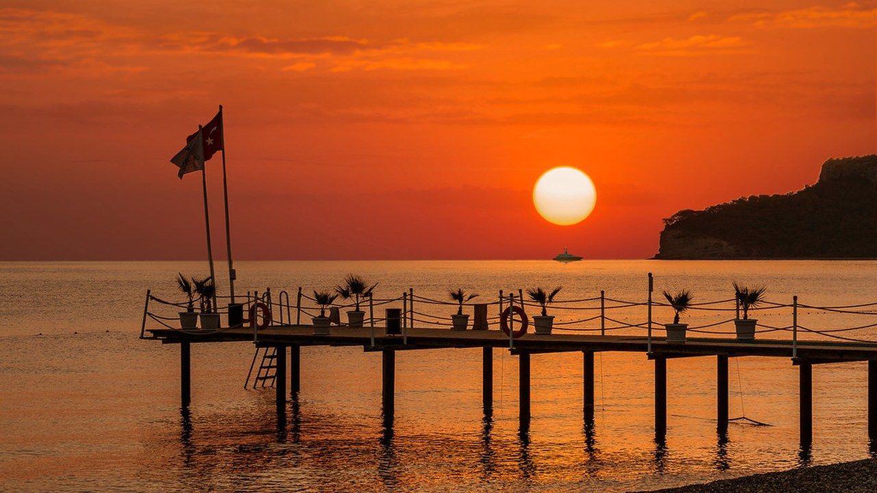 Sunset over the pier at Ayışığı Beach in Kemer, Antalya