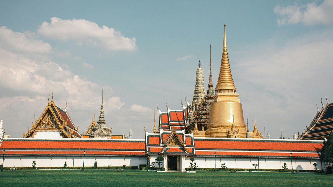 Wide view of the Grand Palace in Bangkok with golden stupas and traditional Thai architecture