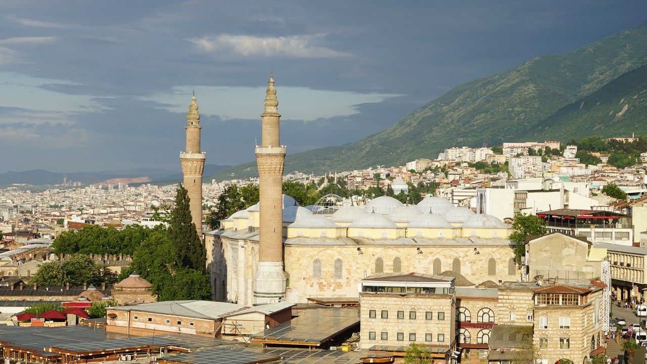 Panoramic view of Bursa Grand Mosque with its twin minarets, domes and Bursa cityscape in Turkey