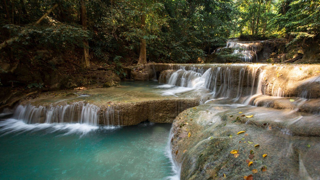 Tiered Erawan Waterfalls with turquoise pools surrounded by tropical forest in Kanchanaburi, Thailand