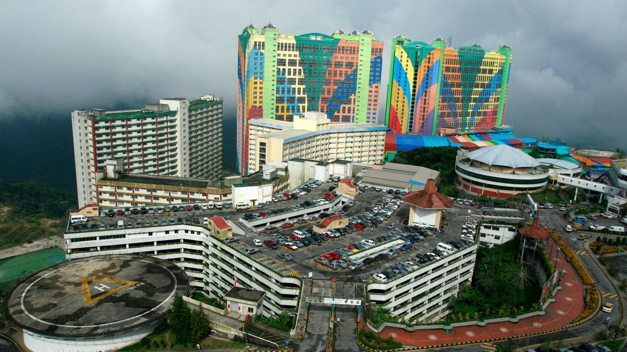Aerial wide view of Genting Highlands and the colorful First World Hotel surrounded by misty mountains in Malaysia