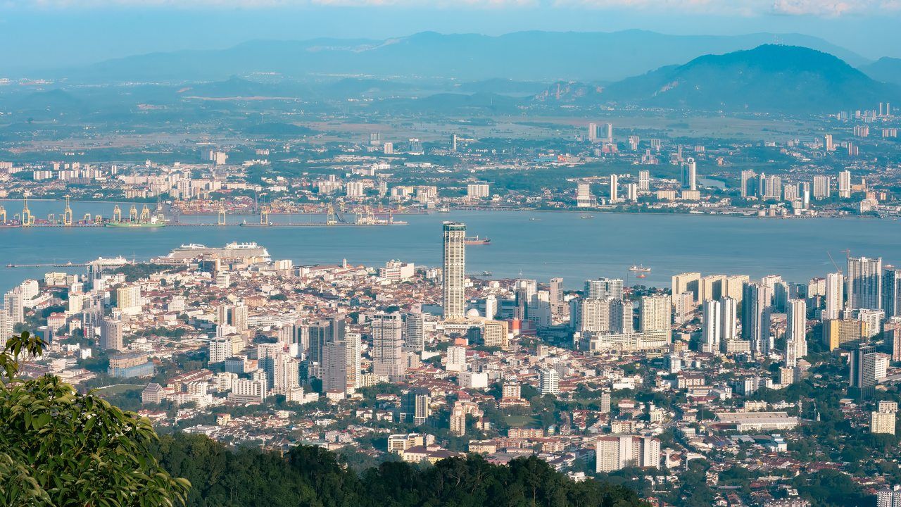 Panoramic view of George Town, Penang with the city skyline, waterfront and distant hills in Malaysia.
