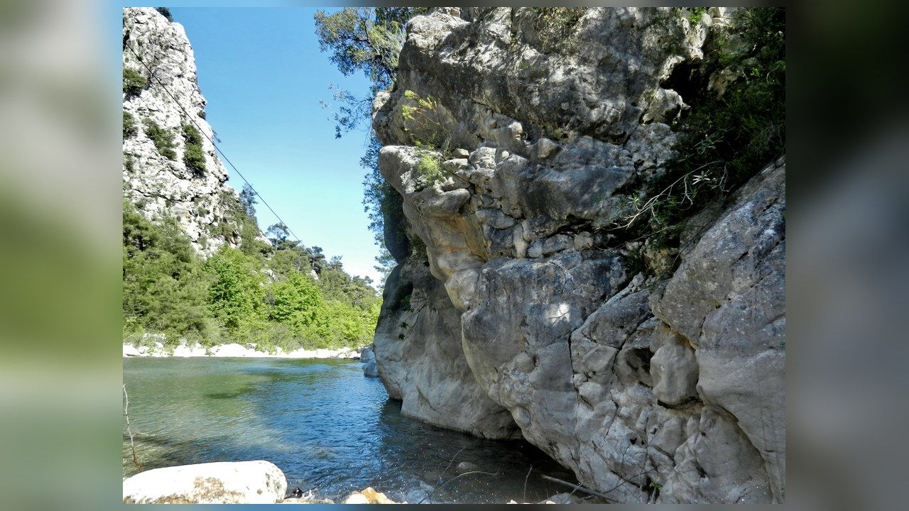 Turquoise river flowing between rocky cliffs in Göynük Canyon