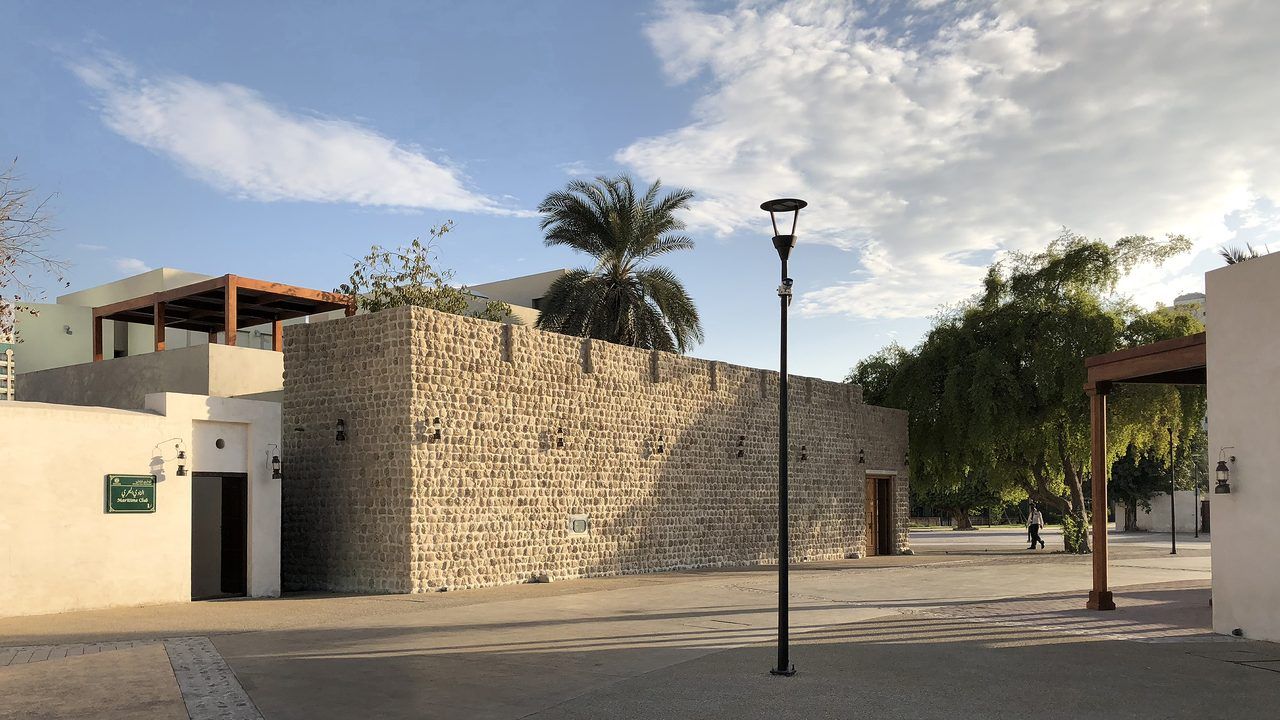 Traditional architecture and palm trees in the Heart of Sharjah heritage district, UAE
