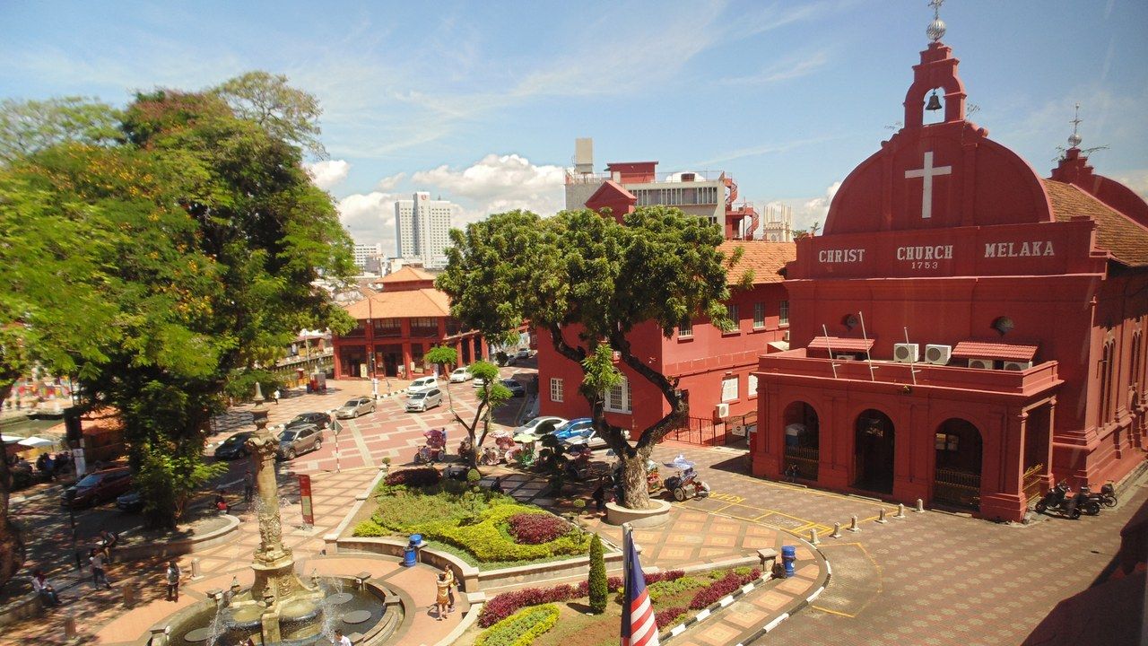Wide view of historic Dutch Square and Christ Church in Melaka, Malaysia, surrounded by gardens and colonial