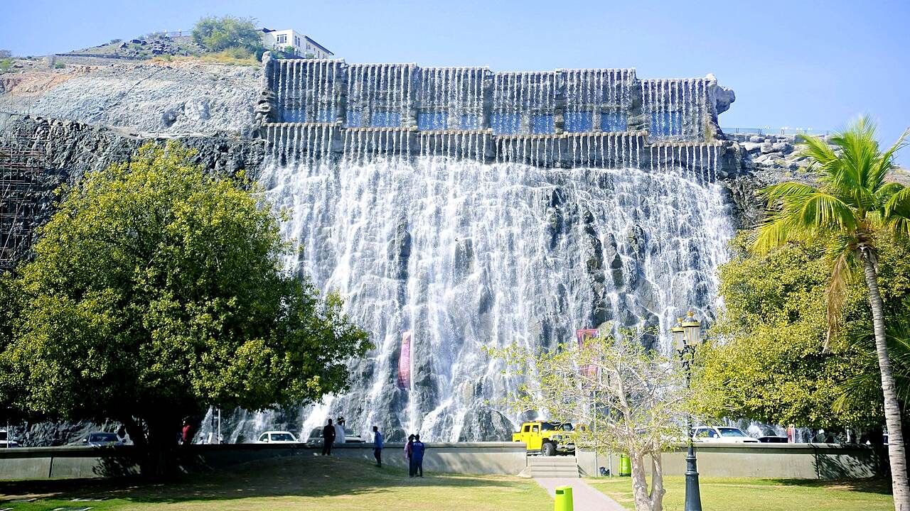 Khorfakkan Waterfall surrounded by mountains and palm trees in Sharjah, UA