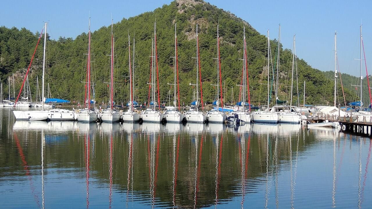 Peaceful marina and forested bay at Orhaniye near Kizkumu Beach.