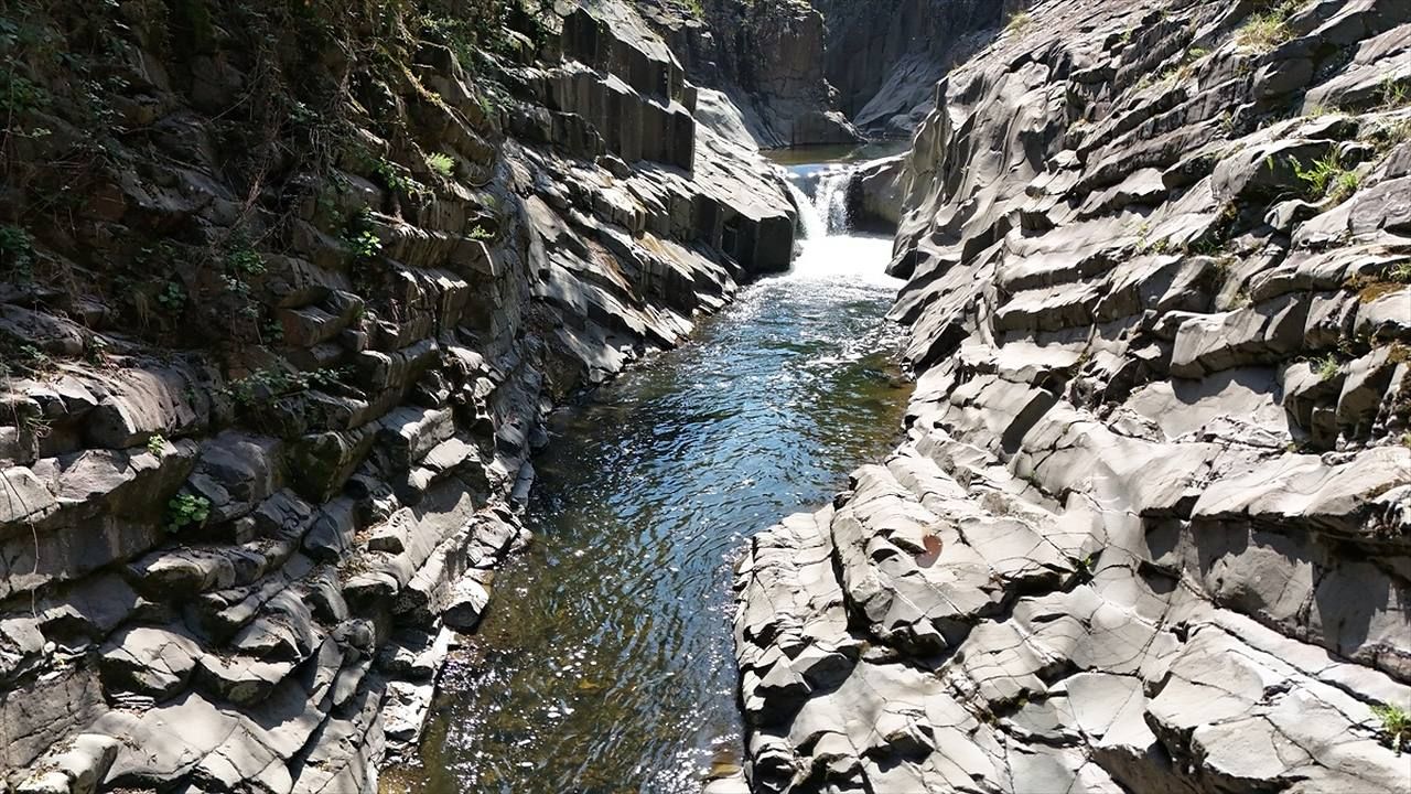 Clear stream flowing between the dramatic rock walls of Küpkaya Canyon