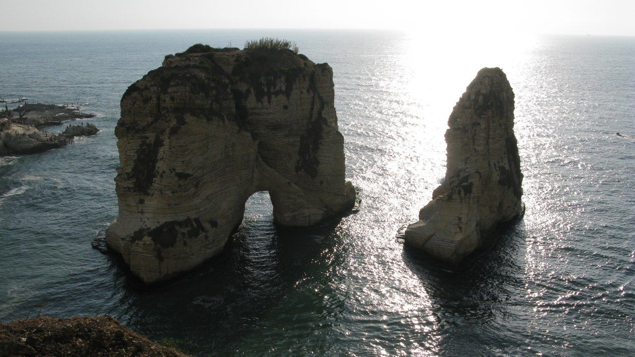 Wide view of the iconic Raouche Pigeon Rocks rising from the Mediterranean Sea in Beirut, Lebanon.