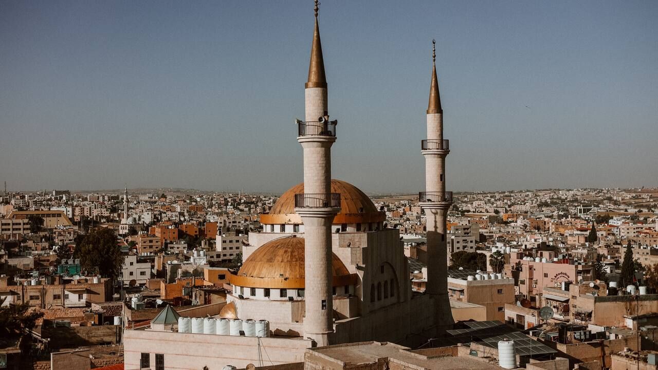 Wide aerial view of a mosque and the historic cityscape of Madaba, Jordan