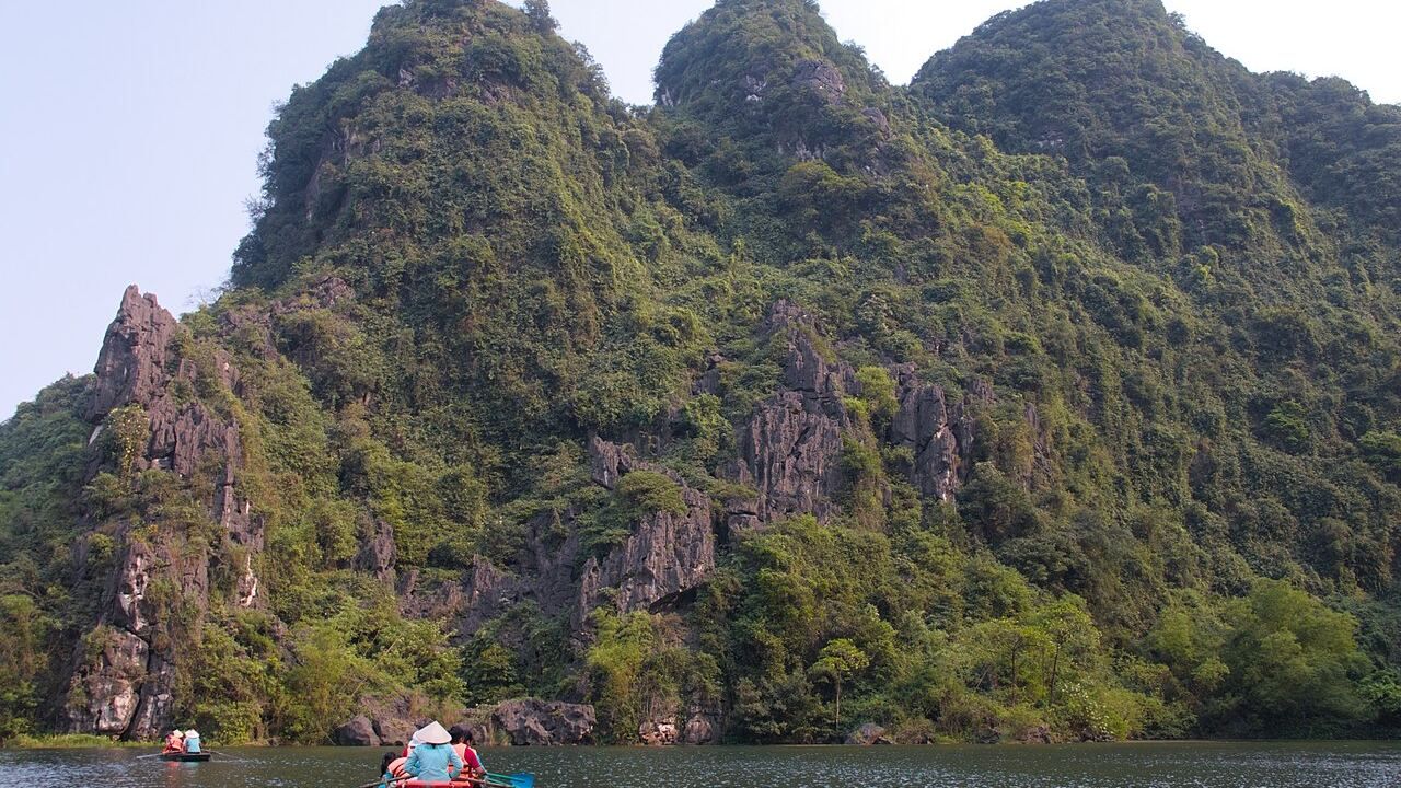 Tour boats on the river among limestone mountains in Trang An Ninh Binh Vietnam