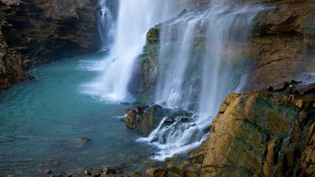 Turquoise water cascading over rocky cliffs at Soğucak Waterfall in Sakarya