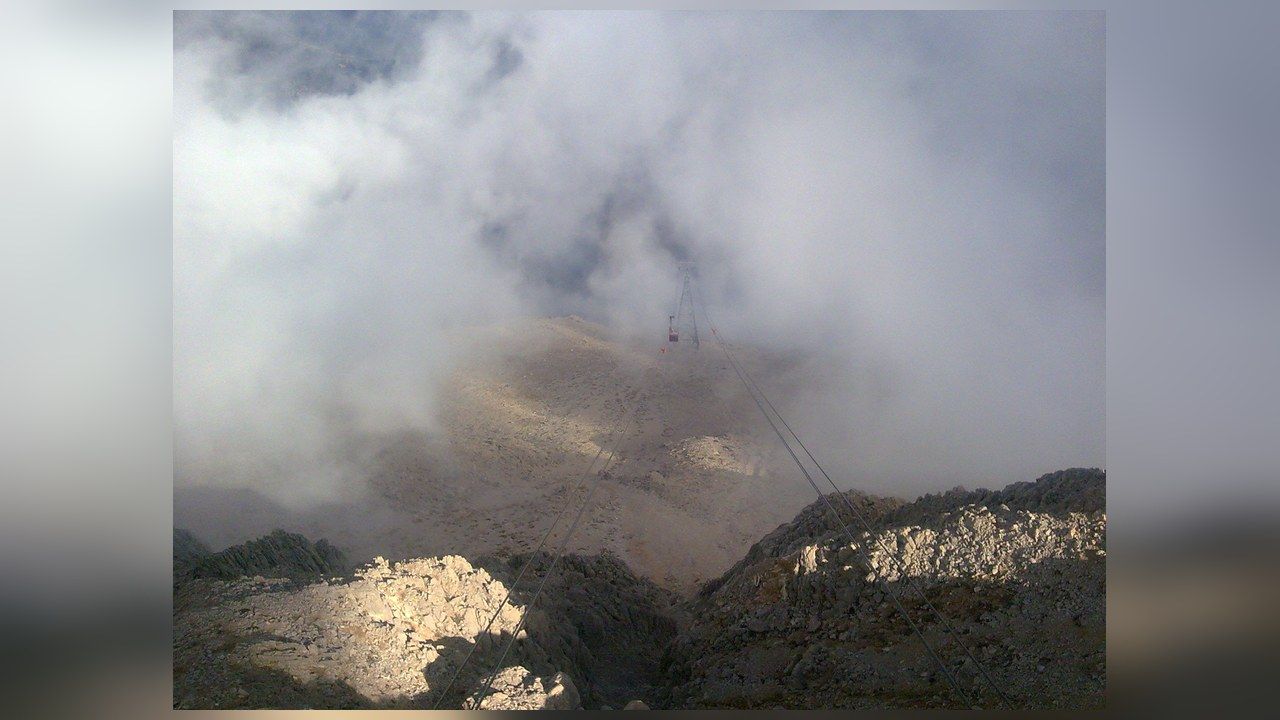 Olympos cable car ascending through clouds toward the summit of Mount Tahtalı