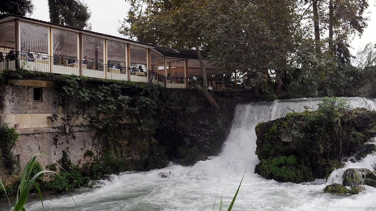 Tarsus Waterfall flowing beside a tree-lined terrace in southern Turkey.