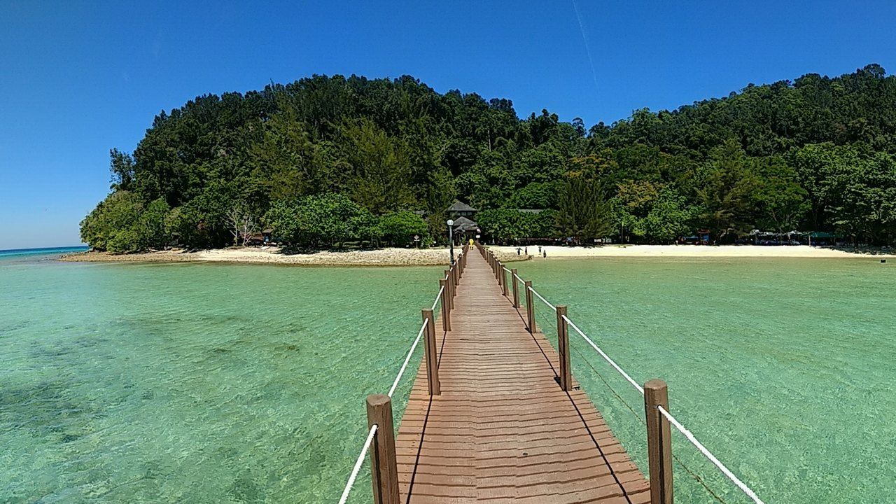 Turquoise waters, tropical beach and lush forest on Gaya Island in Tunku Abdul Rahman Marine Park, Sabah, Malaysia.