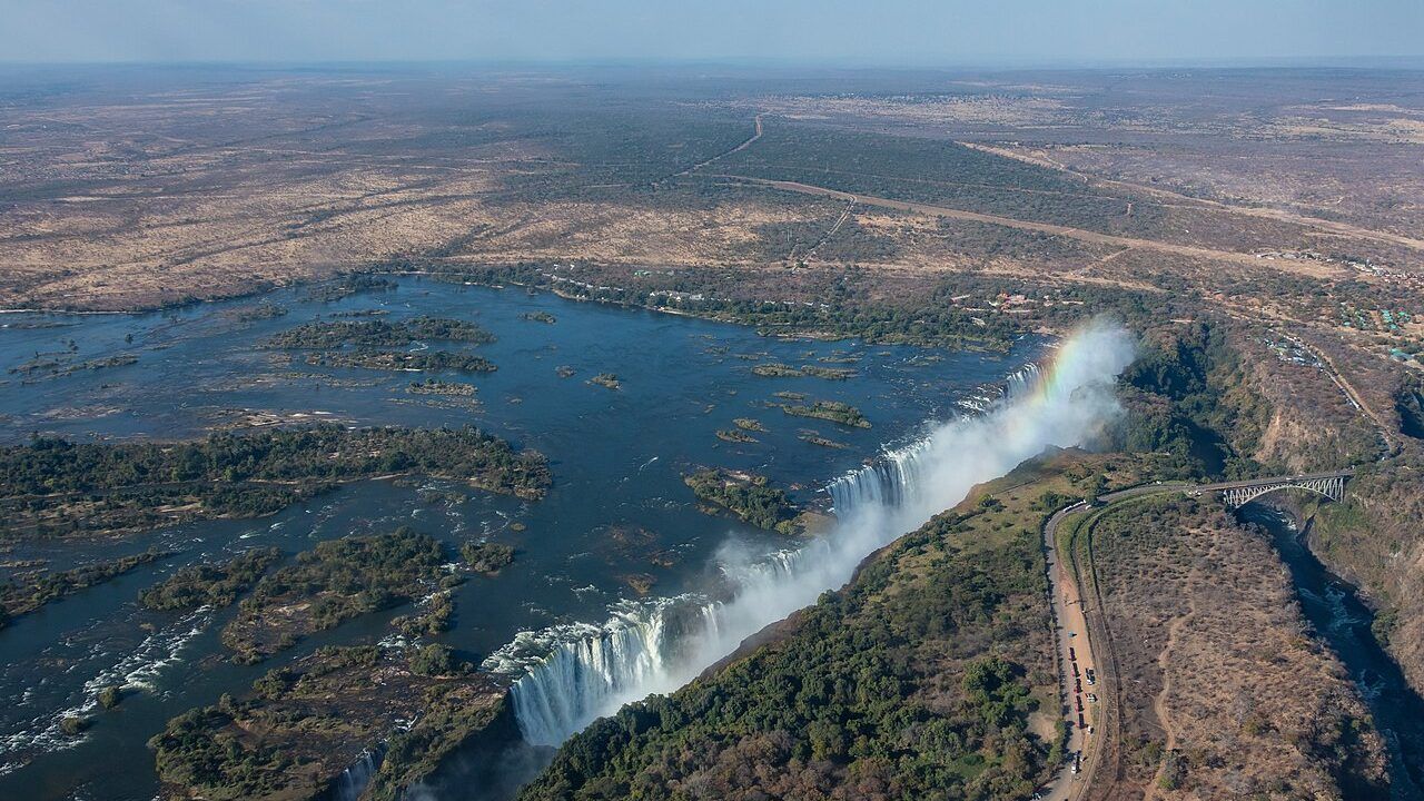 Aerial view of Victoria Falls on the Zambezi River at the Zambia-Zimbabwe border, with the waterfalls, river islands and gorge visible.