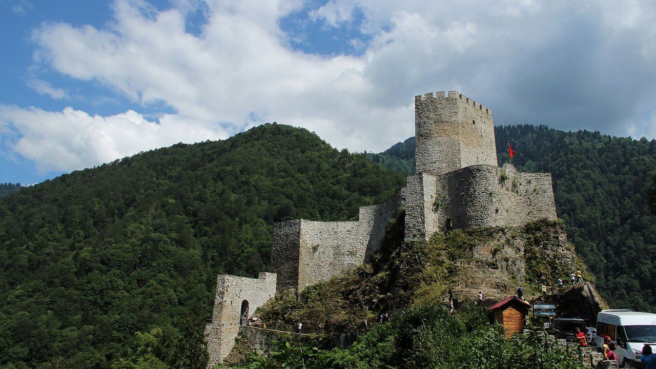 Wide view of Zilkale Castle rising above a forested mountain valley in Rize